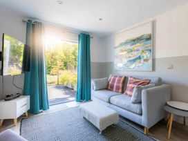 A living room with a television and sofa at 2 Bedrooms overlooking Little Petherick Creek in Little Petherick