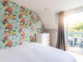 A bedroom with floral wallpaper and a dresser at 2 Bedrooms overlooking Little Petherick Creek in Little Petherick