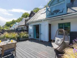 An outdoor deck with table and chairs at 2 Bedrooms overlooking Little Petherick Creek Little Petherick