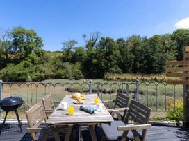 An outdoor seating area with a table and chairs at 2 Bedrooms overlooking Little Petherick Creek Little Petherick