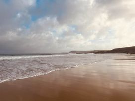 A beach with waves lapping the shore at 2 Bedrooms overlooking Little Petherick Creek Little Petherick