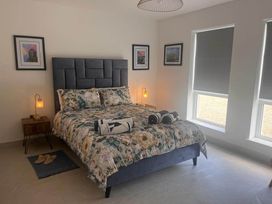 A bedroom with a bed and bedside table at Sunset Cottage Sleeps 6 with Parking Garden in Magilligan near Limavady
