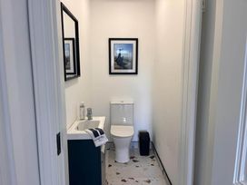 A bathroom with a toilet and sink at Sunset Cottage Sleeps 6 with Parking Garden Magilligan near Limavady