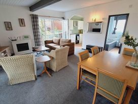A living room with a sofa, armchairs, and dining table at Forest Retreat Sleeps 4 2Bed with Parking in Woolsery near Bideford