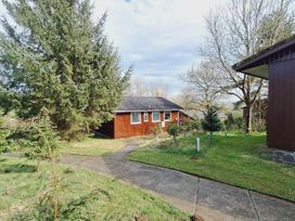 A cabin with a pathway surrounded by trees at Forest Retreat Sleeps 4 2Bed with Parking in Woolsery near Bideford