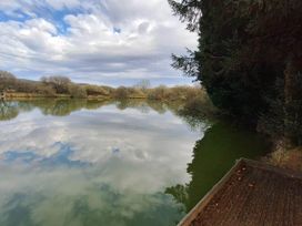 A lake with reflections of trees and sky at Forest Retreat Sleeps 4 2Bed with Parking Woolsery near Bideford