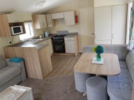 A kitchen and living area with a dining table at Caravan Sleeps4 Pet friendly with Parking Available in Skegness