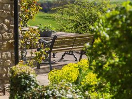 A garden with a bench and table at Stunning 3 Bedroom Cottage near Historic York Ampleforth