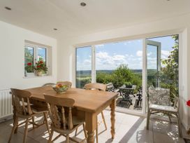 A dining room with a wooden table and chairs at Stunning 3 Bedroom Cottage near Historic York in Ampleforth