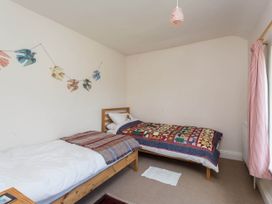 A bedroom with two beds and a garland of birds at Stunning 3 Bedroom Cottage near Historic York Ampleforth