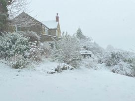A house surrounded by snow and trees at Stunning 3 Bedroom Cottage near Historic York in Ampleforth