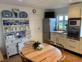 A kitchen with a table and chairs at House Sleeps 8 Close to Beach Free parking in Mullion