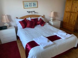A bedroom with a bed, bedside lamps, and a dresser at House Sleeps 8 Close to Beach Free parking, Mullion