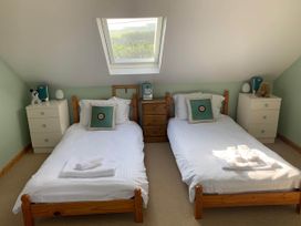Two single beds with a carpet and furniture at House Sleeps 8 Close to Beach Free parking in Mullion
