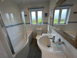 A bathroom with a bathtub and sink at House Sleeps 8 Close to Beach Free parking, Mullion