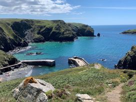 A coastal scene with cliffs and a pier at House Sleeps 8 Close to Beach Free parking in Mullion