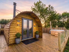 A wooden cabin with a hot tub at The Lodge at Brambles Farm Sleeps 4 Hot Tub in Leek