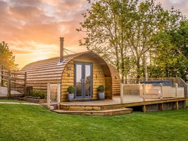 A wooden cabin with a deck and hot tub at The Lodge at Brambles Farm Sleeps 4 Hot Tub in Leek