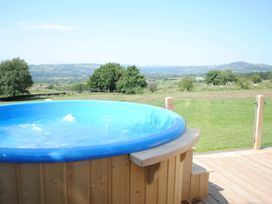 A hot tub on a wooden deck with a view at The Lodge at Brambles Farm Sleeps 4  Hot Tub Leek