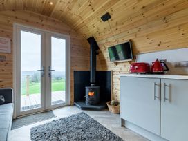 A living room with double doors and a wood stove at The Lodge at Brambles Farm Sleeps 4  Hot Tub in Leek