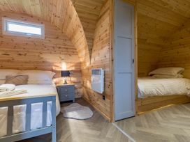 A bedroom with two beds and a bedside table at The Lodge at Brambles Farm Sleeps 4 Hot Tub Leek