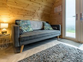 A snug area with a sofa and lamp at The Lodge at Brambles Farm Sleeps 4  Hot Tub in Leek