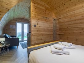 A bedroom with a bed and sofa at The Lodge at Brambles Farm Sleeps 4 Hot Tub in Leek
