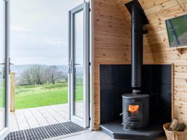 A room with a wood stove and double doors leading to outside at The Lodge at Brambles Farm Sleeps 4  Hot Tub in Leek