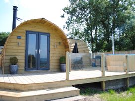 A wooden structure with double doors and a hot tub at The Lodge at Brambles Farm Sleeps 4 Hot Tub in Leek