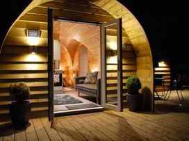 A living room with a couch and door at The Lodge at Brambles Farm Sleeps 4 Hot Tub in Leek