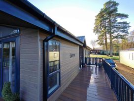 An exterior view of a lodge with a deck and trees at Dunoon 3Bed Lodge Sleeps 6 Pet Friendly near Dunoon