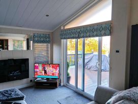 A living room with a television and sliding door at Dunoon 3Bed Lodge Sleeps 6 Pet Friendly near Dunoon