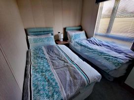 A bedroom with two beds and a bedside table at Dunoon 3Bed Lodge Sleeps 6 Pet Friendly near Dunoon