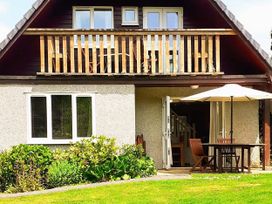 A house exterior with a balcony, table with chairs, and plants at Cosy 3 Bedroom House on Cornish estate with pool St Tudy