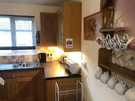 A kitchen with sink, window, and storage cabinets at Cosy 3 Bedroom House on Cornish estate with pool St Tudy