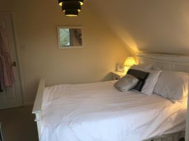 A bedroom with a bed and lamp at Cosy 3 Bedroom House on Cornish estate with pool in St Tudy