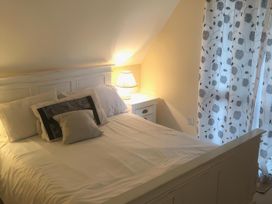 A bedroom with a bed and nightstand at Cosy 3 Bedroom House on Cornish estate with pool in St Tudy