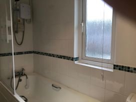 A bathroom with a bathtub and showerhead at Cosy 3 Bedroom House on Cornish estate with pool St Tudy