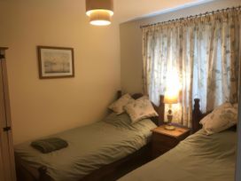A bedroom with two single beds and a lamp in Cosy 3 Bedroom House on Cornish estate with pool St Tudy