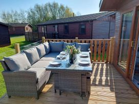 An outdoor patio with seating and a table at Lakeland Lodge 3Bed 2 Bath Private Patio, Carnforth