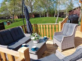 An outdoor seating area with a sofa and table at Lakeland Lodge 3Bed 2 Bath Private Patio in Carnforth