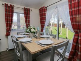 A dining room with a table and chairs at Lakeland Lodge 3Bed 2 Bath Private Patio in Carnforth