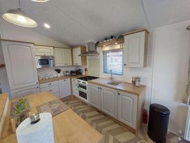 A kitchen with cabinets and appliances at Lakeland Lodge 3Bed 2 Bath Private Patio in Carnforth