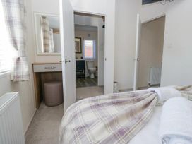 A bedroom with a mirror and doorway leading to a bathroom at Lakeland Lodge 3Bed 2 Bath Private Patio in Carnforth