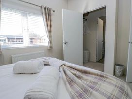 A bedroom with a bed and towels at Lakeland Lodge 3Bed 2 Bath Private Patio in Carnforth