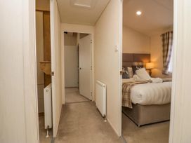 A view of a bedroom with a bed and lamp at Lakeland Lodge 3Bed 2 Bath Private Patio in Carnforth