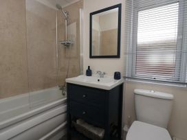 A bathroom with a bathtub, shower, and mirror at Lakeland Lodge 3Bed 2 Bath Private Patio, Carnforth