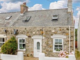 A cottage with gravel path and flowers at Cottage Sleeps 5 with Parking and Garden in Carreglefn