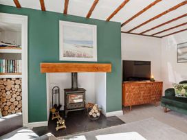 A living room with a fireplace and a television at Cottage Sleeps 5 with Parking and Garden in Carreglefn