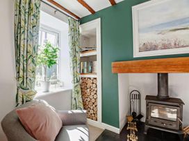 A living room with a fireplace and bookshelves at Cottage Sleeps 5 with Parking and Garden in Carreglefn